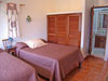 Guest bedroom has two full-size beds and bath with shower. Garden view.