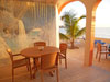 Covered patio with mural of La Sarena's cenote. Two tables will seat 12.